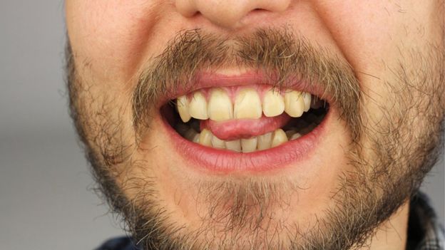 Boca de hombre con lengua y dientes.