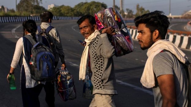 Un grupo de hombres retorna a sus hogares en medio del cierre de India por la pandemia.