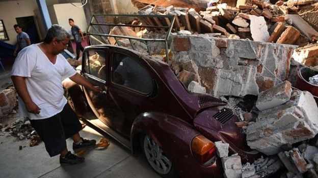 Un hombre observa su auto destrozado por el terremoto en la localidad mexicana de Juchitan de Zaragoza.