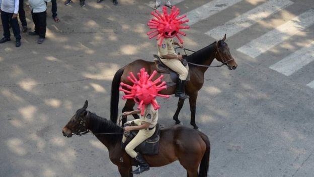 Police on horseback wearing virus helmets