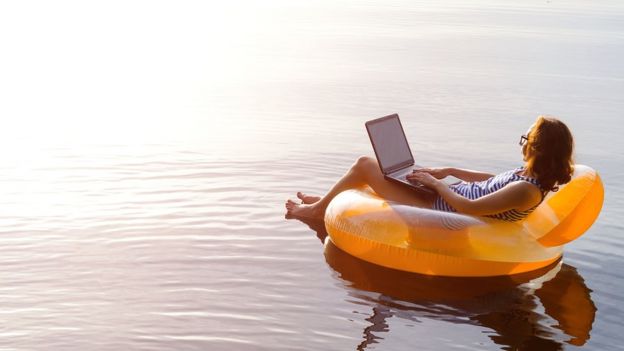 Mujer en un inflable con una computadora.