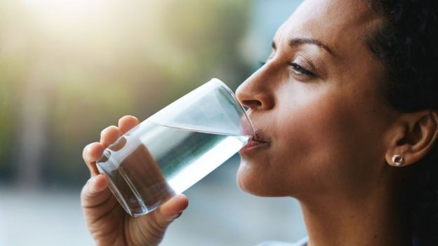 Mujer tomando un vaso con agua