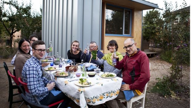 Na foto, Bobby (C, de jaqueta azul) e membros da vizinhança em frente à primeira microcasa construída em projeto que estimula americanos a permitirem a instalação dessas moradias no quintal de suas casas para abrigar pessoas até então sem-teto