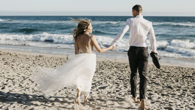 Pareja de casados en la playa.