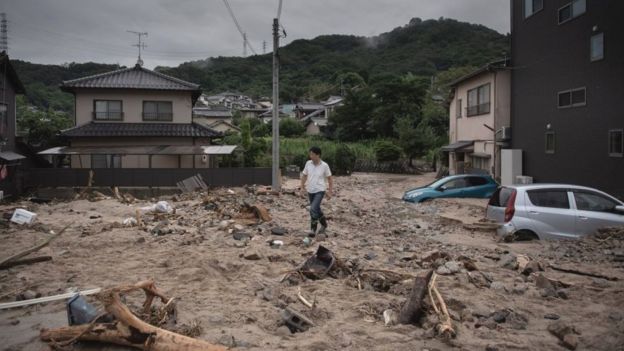 Man walks past a devastated street during floods in Saka