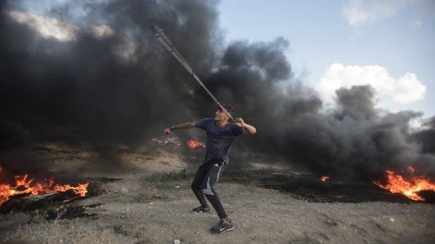 A Palestinian protester takes part during the clashes with Israeli troops near the border with Israel in the east of Gaza City on, 20 July 2018.
