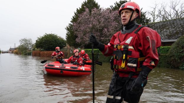 Humberside Fire and Rescue service search along a flooded street for residents after the River Aire bursts its banks