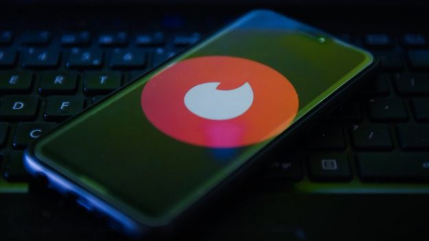 Логотип Tinder отображается на мобильном телефоне.