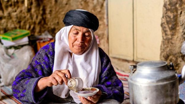 سيدة تعد مشروبا ساخنا في منزلها بقرية ميمند الإيرانية