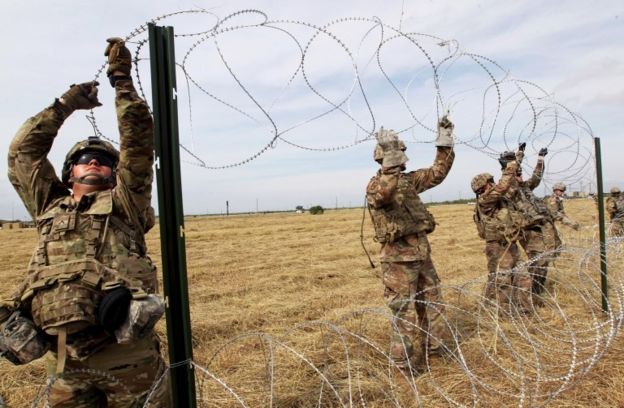 Soldados instalan alambre de púas en la frontera