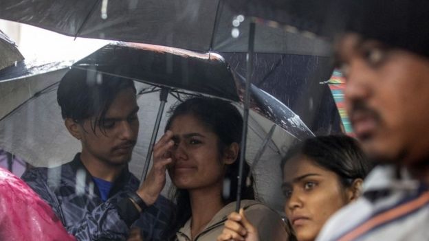 Garota chora ao observar sua casa inundada no Nepal