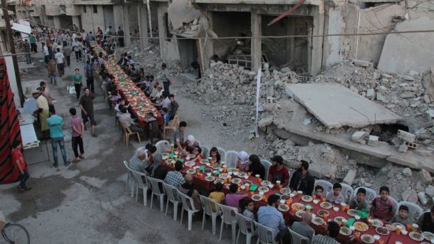 Syrian residents of the rebel-held town of Douma, on the outskirts of the capital Damascus, break their fast with the 