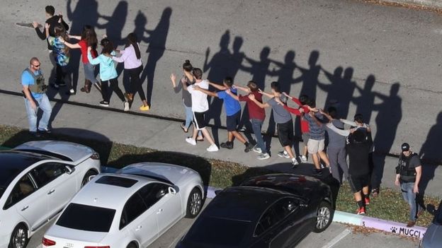 People are brought out of the Marjory Stoneman Douglas High School after a shooting.
