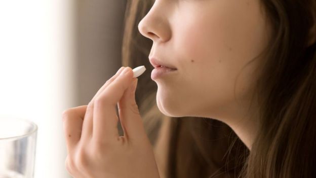 Una mujer tomÃ¡ndose una pastilla