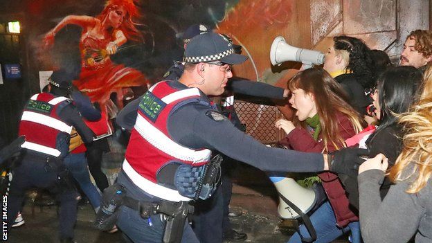 Police officers attempt to stop protesters from storming the back entrance to Melbourne's Athenaeum club, where Court was the keynote speaker on 22 June 2017
