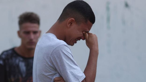 People wait for information in front of the training center of Rio"s soccer club Flamengo