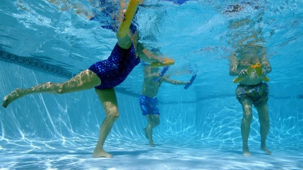 Mujeres y hombres en una piscina.