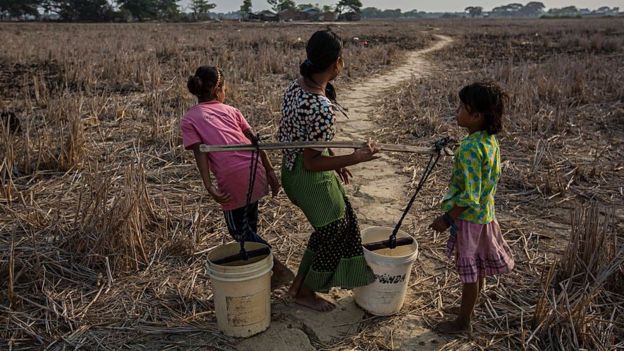 Una mujer con dos niños en una zona rural de Birmania.