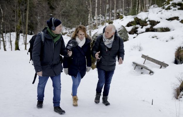 Neil McCarthy, Marit Higraff y Ketil Kversoy caminando en un bosque nevado.