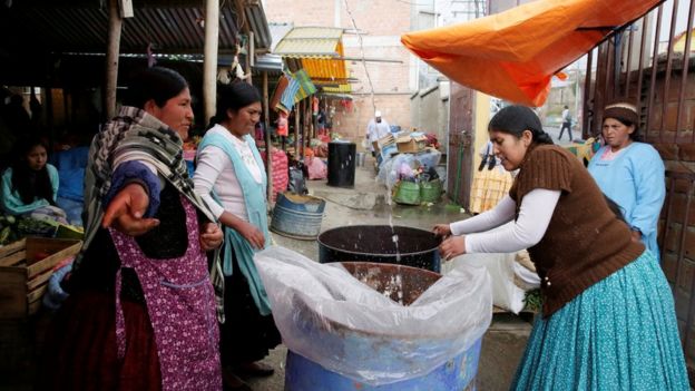 Mujeres recuperan el agua de la lluvia en barriles en La Paz