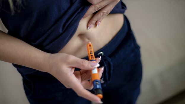 Una mujer se aplica una inyecciÃ³n subcutÃ¡nea en el abdomen.