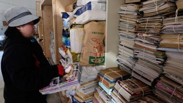 A worker sorts newspapers and magazines for recycling in the "eco-town" of Kamikatsu