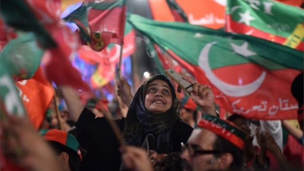 Supporters of Pakistani cricket star-turned-politician and head of the Pakistan Tehreek-e-Insaf (PTI) Imran Khan, cheer and wave flags during a rally during the last campaign day, in Lahore, on July 23, 2018