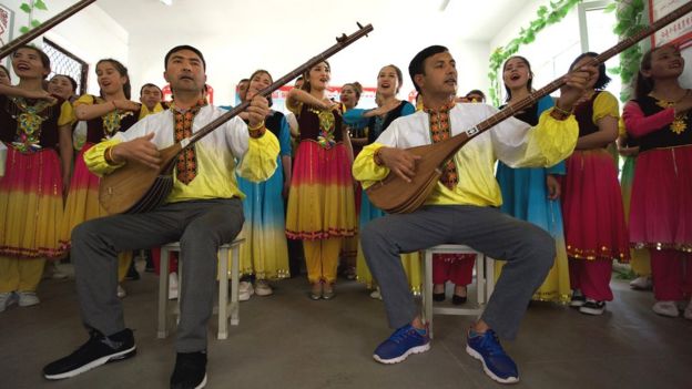 Uigures cantando y con instrumentos musicales en un aula