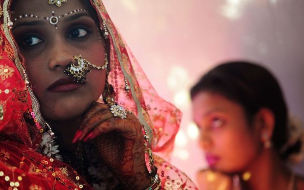 An Indian bride (L) waits with her sister (R) for her wedding ceremony.