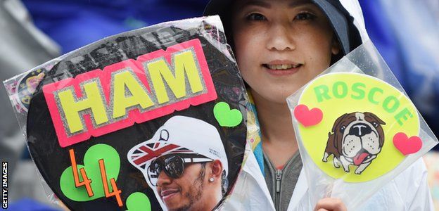 Japanese GP fan at Suzuka holds up a paddle board of Lewis Hamilton and his dog Roscoe
