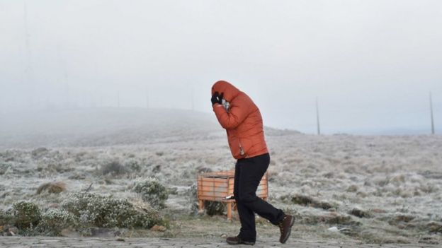 Pessoa caminhando com agasalho e capuz em Santa Catarina