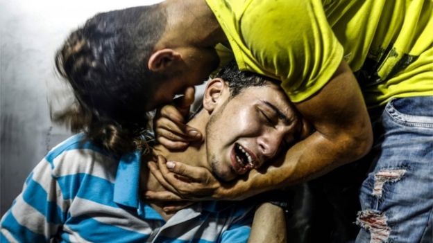 شاب فلسطيني ينتحب على أخيه في مستشفى الشفاء في غزة