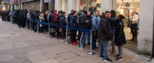 Shoppers queue outside a branch of Foot Locker on Oxford Street, London, as many retailers offer one day sales for "Black Friday" in 2014