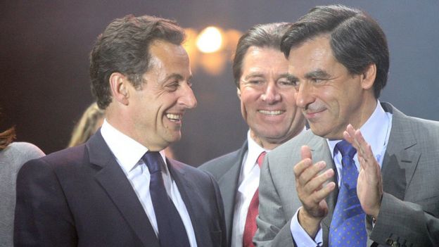 Nicolas Sarkozy, left, laughs on stage alongside Francois Fillon