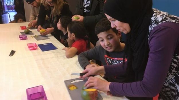 Niños aprenden a picar fruta en un centro comunitario