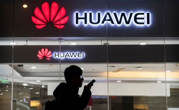 Un ciudadano chino parece hablar por el móvil frente a una tienda de Huawei en Pekín.