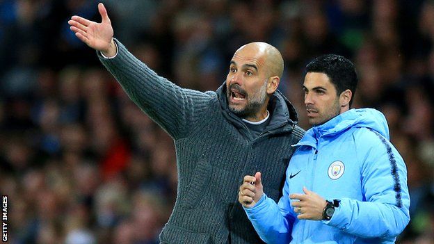 Manchester City manager Pep Guardiola points as he talks to assistant Mikel Arteta (right)