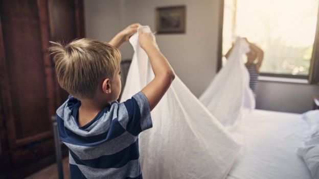 Niño haciendo la cama