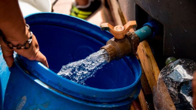 Mujer con balde de agua.