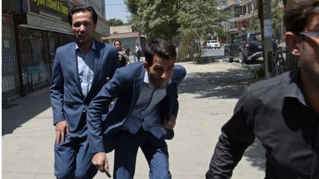 Afghan residents run at the site of a suicide blast near Iraq's embassy in Kabul on 31 July 2017