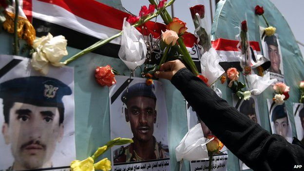 A woman places a flower on a memorial to Yemeni soldiers killed in an al-Qaeda suicide bomb attack on a parade rehearsal in Sanaa in May 2012