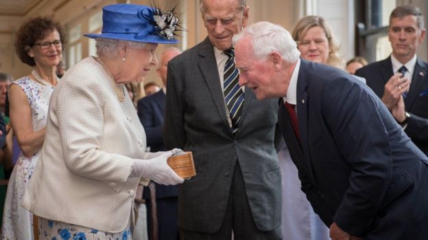 Britain's Queen Elizabeth II, accompanied by Britain's Prince Philip, Duke of Edinburgh, is welcomed by Canada Governor General David Johnston on a visit to Canada House in central London