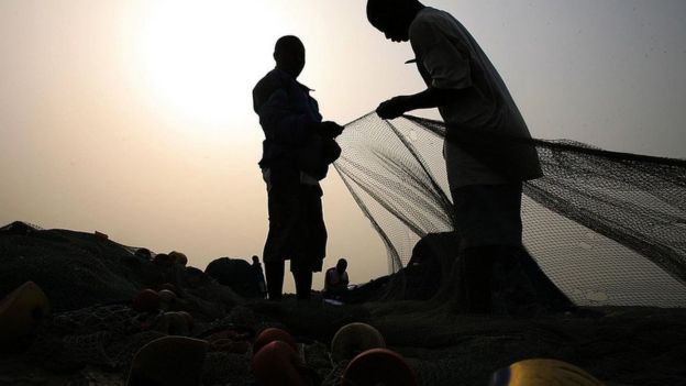 Fishermen prepare their fishing nets in Accra.