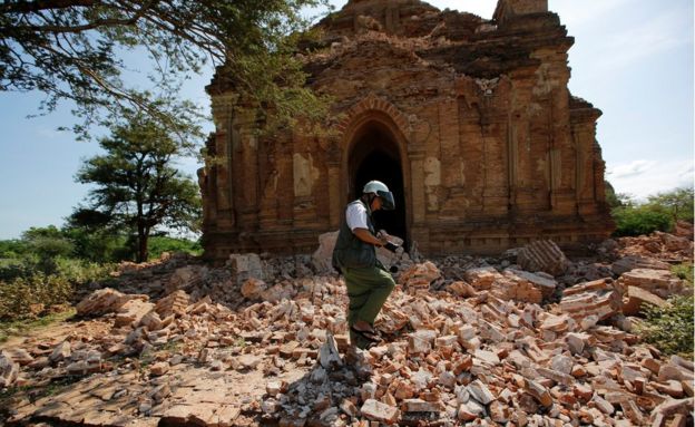 A photographer walks on the rubble of a collapsed pagoda after the earthquake. Taken 25 August 2016.