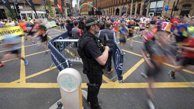 An armed police officer oversees the race