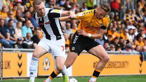 Cameron Norman of Newport County is tackled by Stephen Dooley of Rochdale