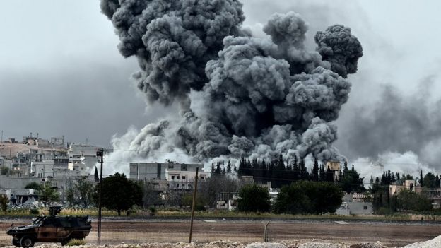 Smoke rises after an air strike on an Islamic State position in the Syrian town of Kobane (12 October 2014)