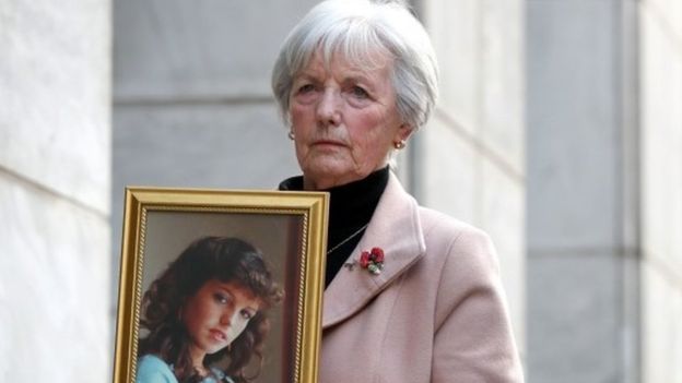 A picture of Marie McCourt holding a picture of her daughter