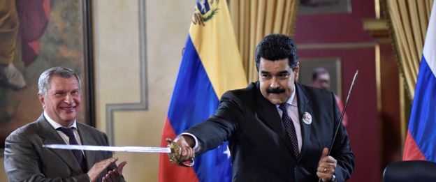 Venezuelan President Nicolas Maduro (R) holds a sword, given as gift by Russian oil company Rosneft's CEO, Igor Sechin, during the signing of agreements at Miraflores presidential Palace in Caracas on July 28, 2016