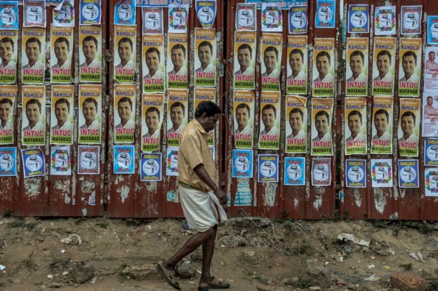 A man walks in front of posters of Rahul Gandhi during the road show after Rahul Gandhi files nominations from Wayanad district on April 4, 2019.